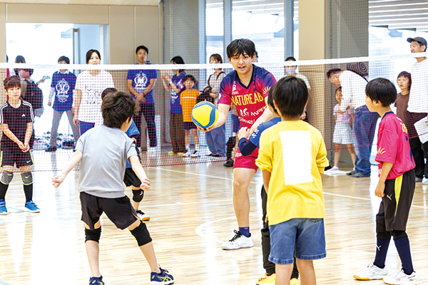 バレー選手とバレーを体験する参加者の子どもたち