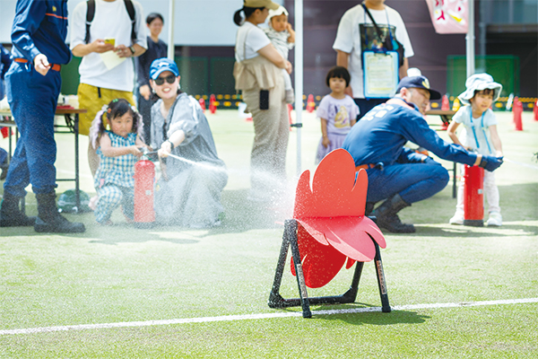 的に向けて消火器を噴射する参加者の様子