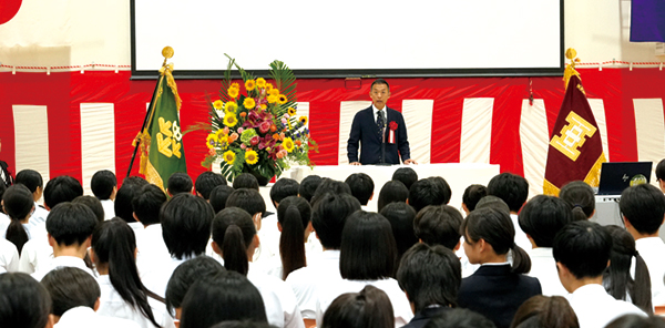 開校式で登壇する長谷部区長と生徒の様子