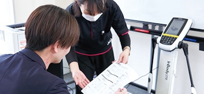 体組成計から出力されたデータを確認するスタッフと参加者の様子