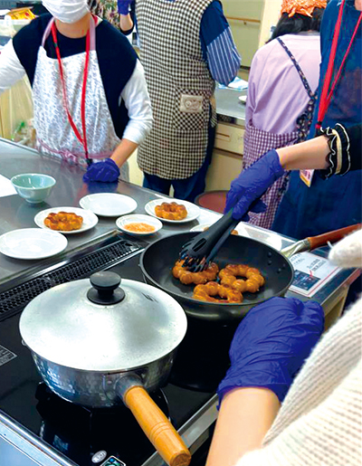 フライパンでドーナツをあげている参加者の様子
