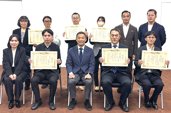 表彰状をかかげる介護サービス事業所の皆さんと区長