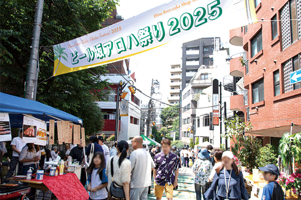 ビール坂アロハ祭り2025の横断幕がかかり屋台が並んだ通り