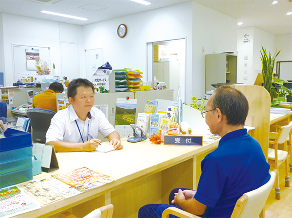 地域包括支援センターの受付窓口で相談員と相談をしている様子