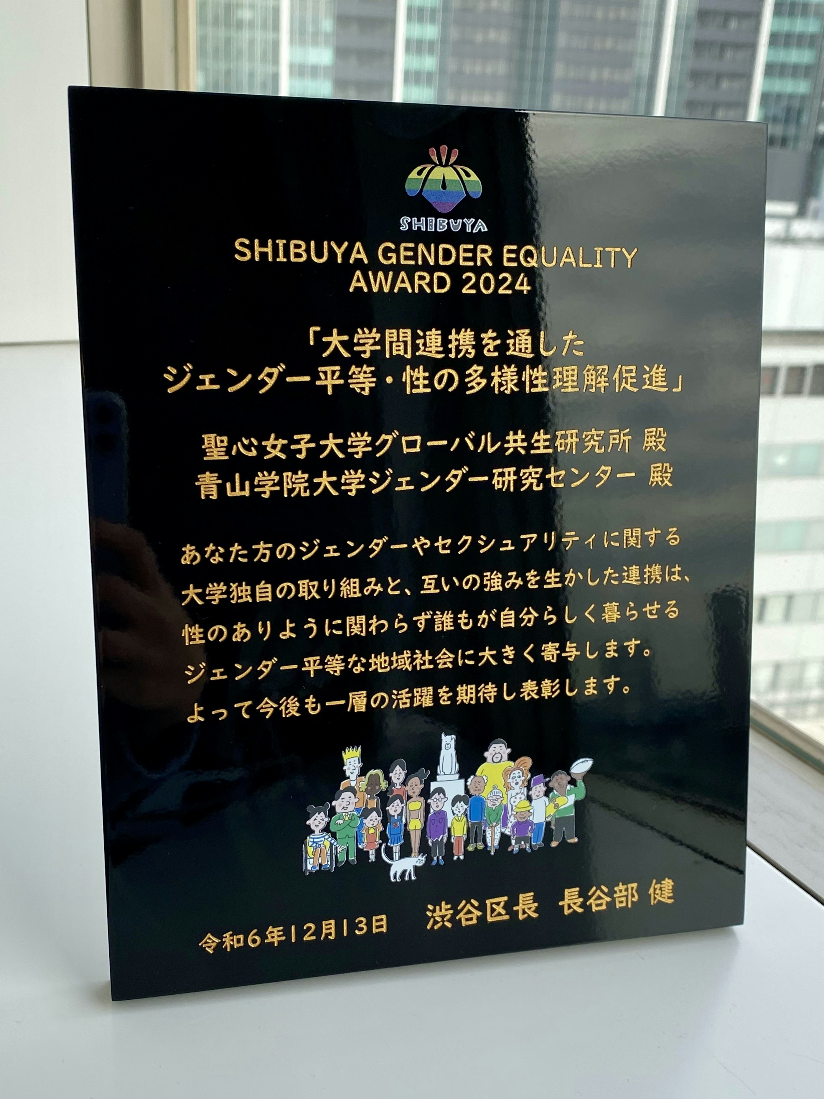 表彰盾の写真。あなた方のジェンダーやセクシュアリティに関する大学独自の取り組みと、互いの強みを生かした連携は、性のありように関わらず誰もが自分らしく暮らせるジェンダー平等な地域社会に大きく寄与します。よって今後も一層の活躍を期待し表彰します。