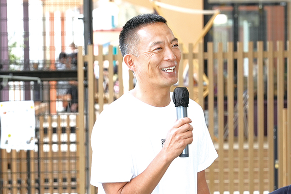 長谷部区長がマイクを持って話している様子