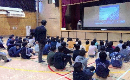 幡代小学校体育館で生徒がみずほ銀行担当者からキャリア教育支援を受けている様子写真