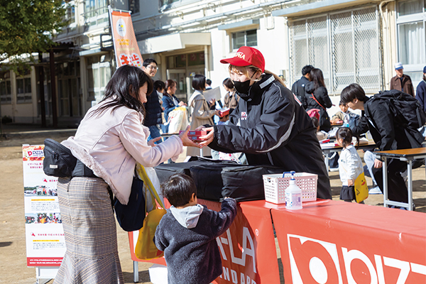 ピザーラのスタッフからピザを受け取る参加者の様子