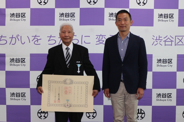 瑞宝単光章を受賞された渋谷消防団元分団長 篠﨑秀大さんと長谷部区長の様子の写真