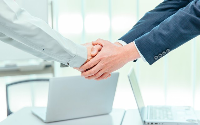 支援が決定し握手する人