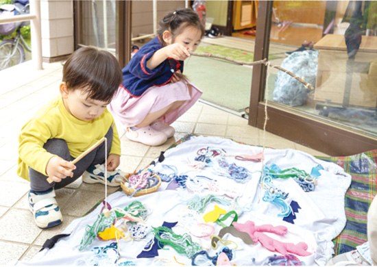 魚釣りゲームを楽しむ子供たち 写真