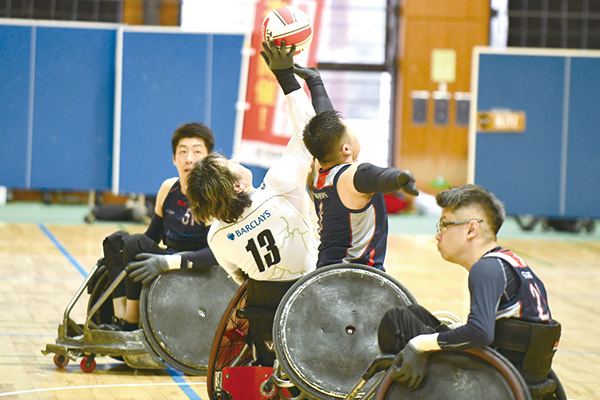 上空に手を伸ばしてボールを取り合う選手たち