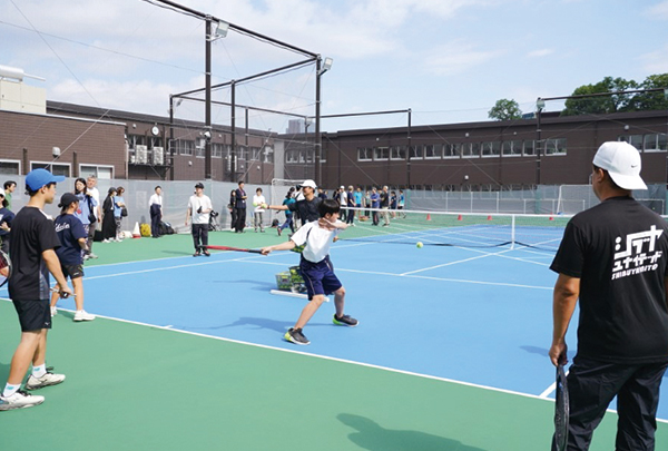 テニスコートでテニスをする部員たち