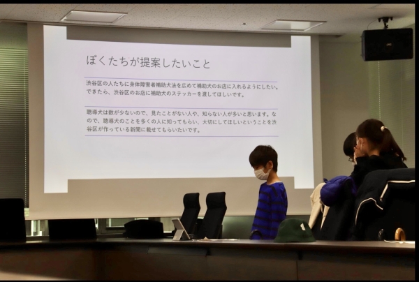 加計塚小学校の4年生達が渋谷区役所で「優しい街シブヤ」の調査結果を報告している様子の写真