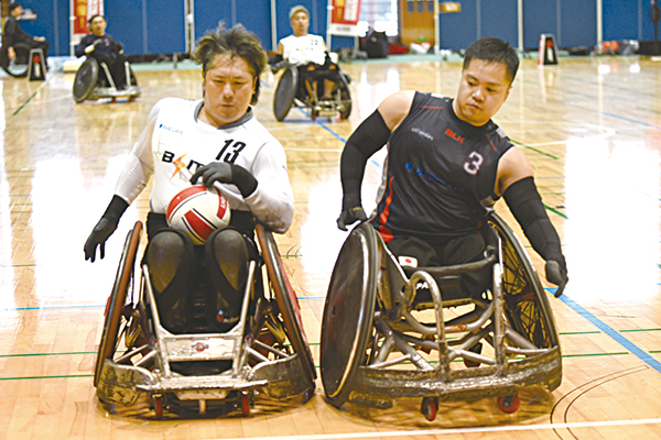 車いすをぶつけ合いラグビーの試合をする選手たち