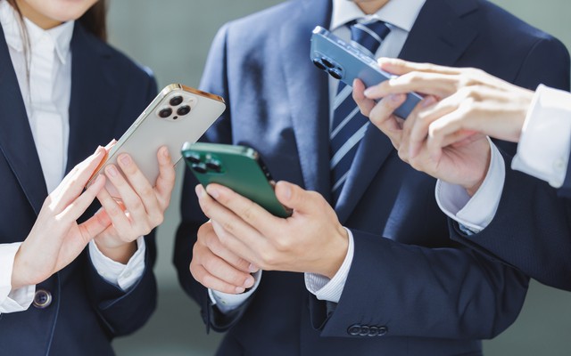 スマホで災害情報を見る会社員