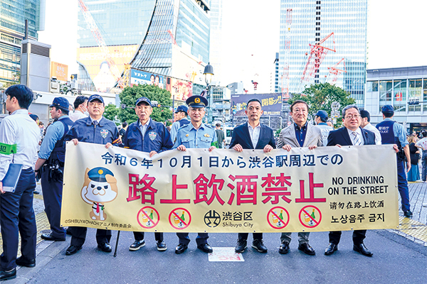 セレモニーの様子。渋谷区長・渋谷警察署長らが「令和6年10月1日から渋谷駅周辺での路上飲酒禁止」と書かれた横断幕を掲げている。