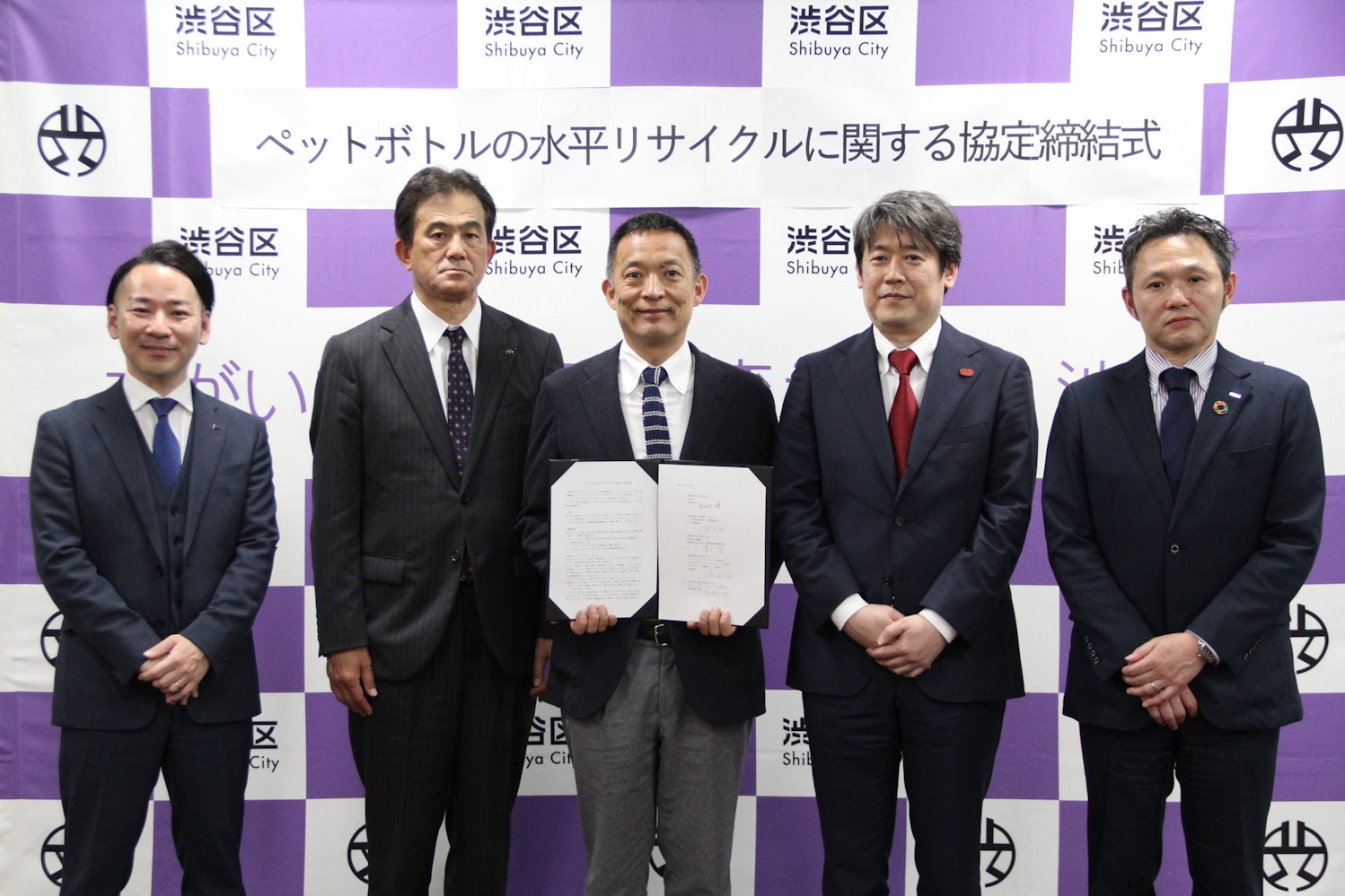 画像：長谷部健区長が各社の代表と並んで協定締結書を持っている様子