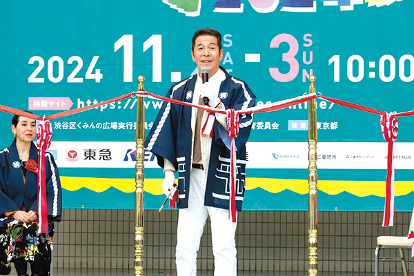 実行委員長の井上順さんがテープを前にスピーチをしている様子