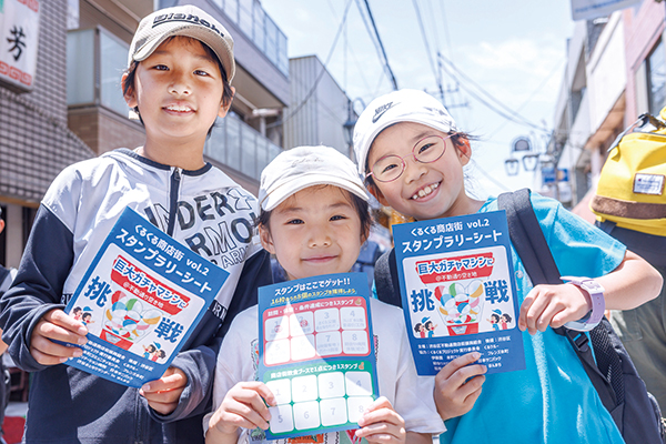 スタンプラリーシートを手に笑顔の子どもたち