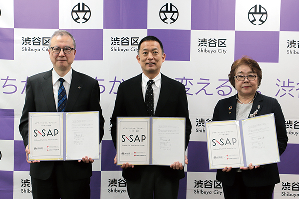 協定書を掲げる皆さんの様子（写真左から 中島 淳 院長（日本赤十字社医療センター）、長谷部 健 渋谷区長、守田 美奈子 学長（日本赤十字看護大学）