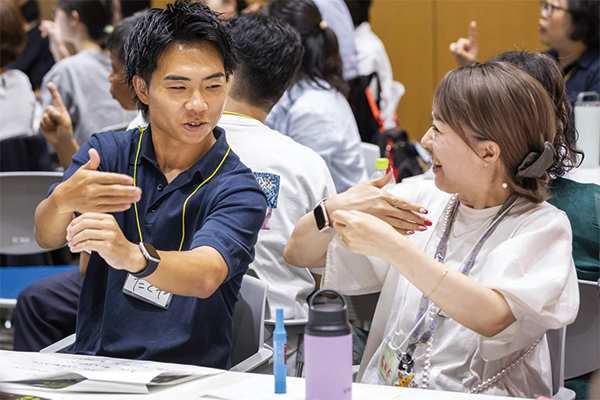 ろう者と並んで手話を教わる参加者の様子