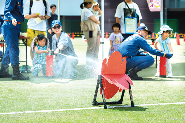 的に向けて消火器を噴射する参加者の様子